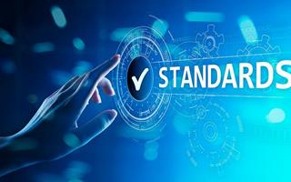 Dieses Konzept über die ISO-Normen zeigt eine Hand, die einen Bildschirm mit dem Wort "Standards" berührt.